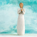 Willow Tree Hero, 9.5”h hand-painted standing resin figure in cream dress holding folded American flag in her arms,  in front of aqua painting