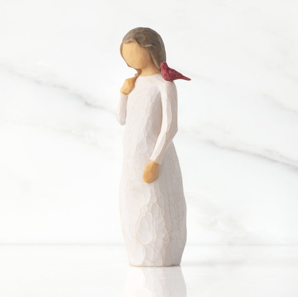 Front view of standing figure in cream dress with cardinal red bird perched on shoulder