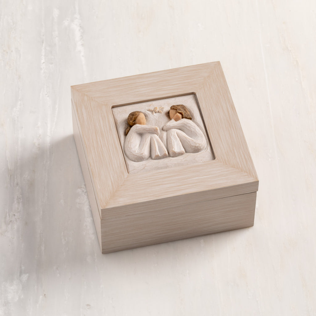 Cream wood box with hinged lid. Inset bas-relief plaque of two seated girls, facing each other.