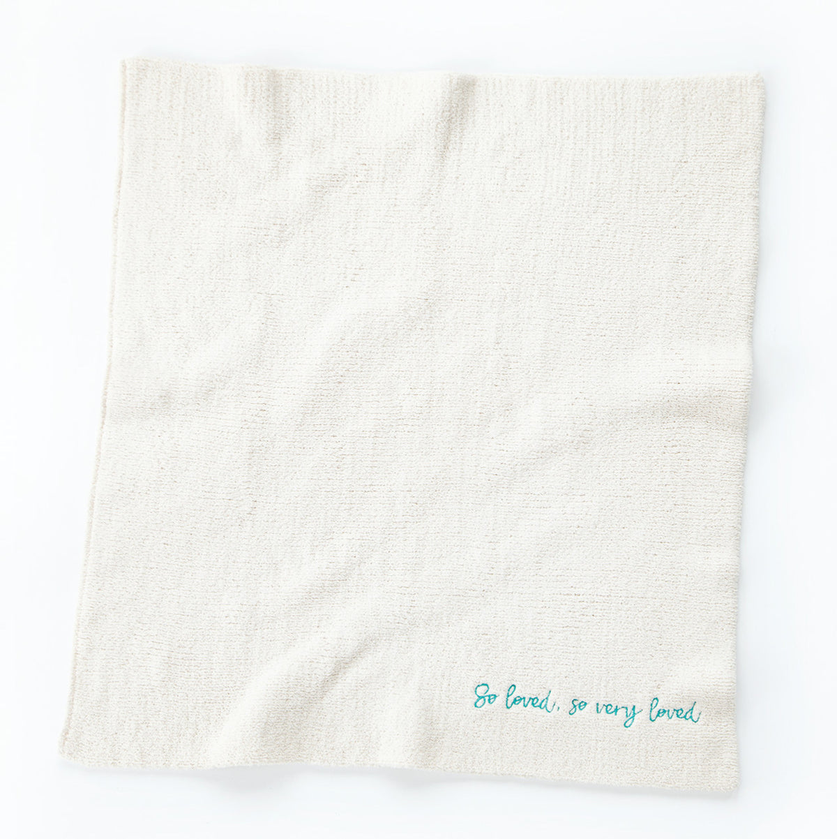 Overview of white towel with 'so loved, so very loved' in light blue in the right corner