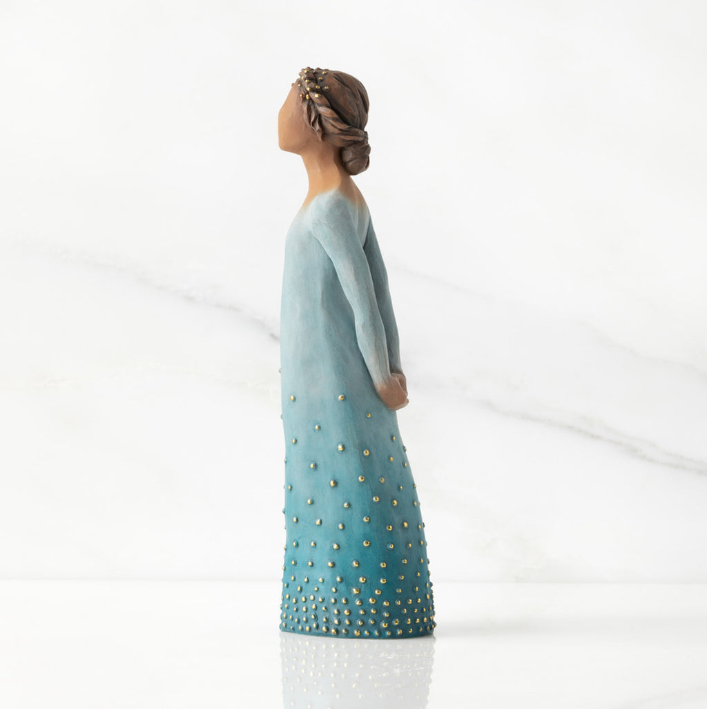 Left profile: Darker-skin figure, arms clasped behind back, hair and deep blue ombré garment dotted with gold leaf