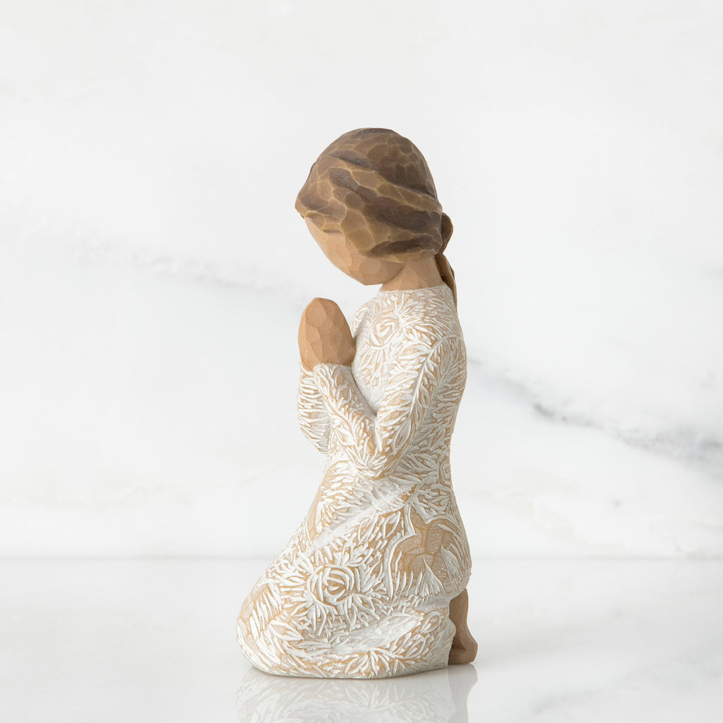 Small brunette girl figurine in white dress kneeling with hands folded - side view