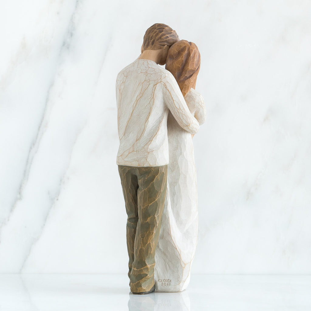 Back view of brunette couple in white hugging one another