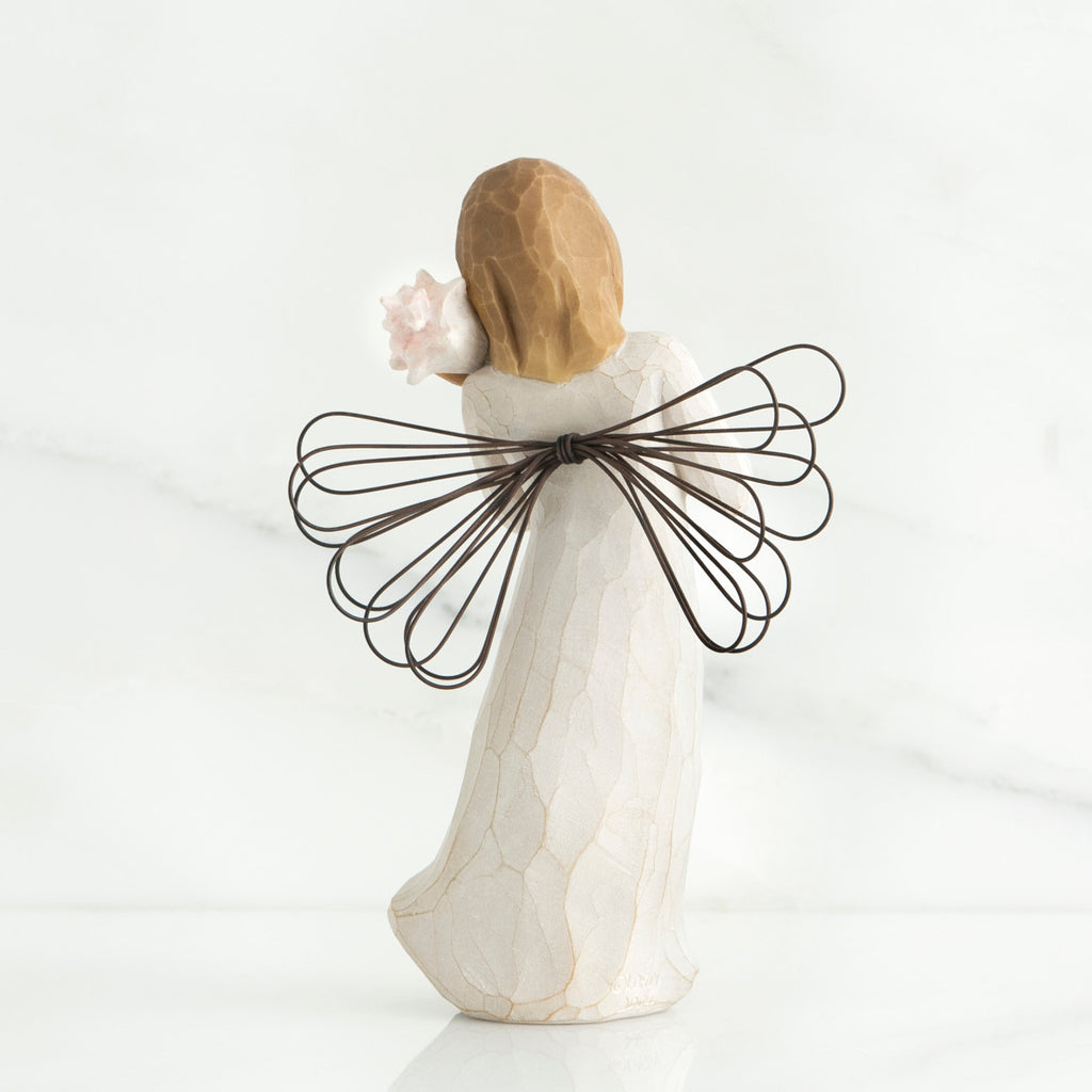 Back view of blonde angel figurine with brown wire wings and white dress