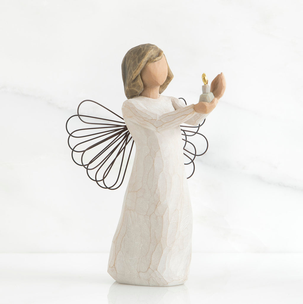 Faceless girl figurine wearing white dress holding up gold candle