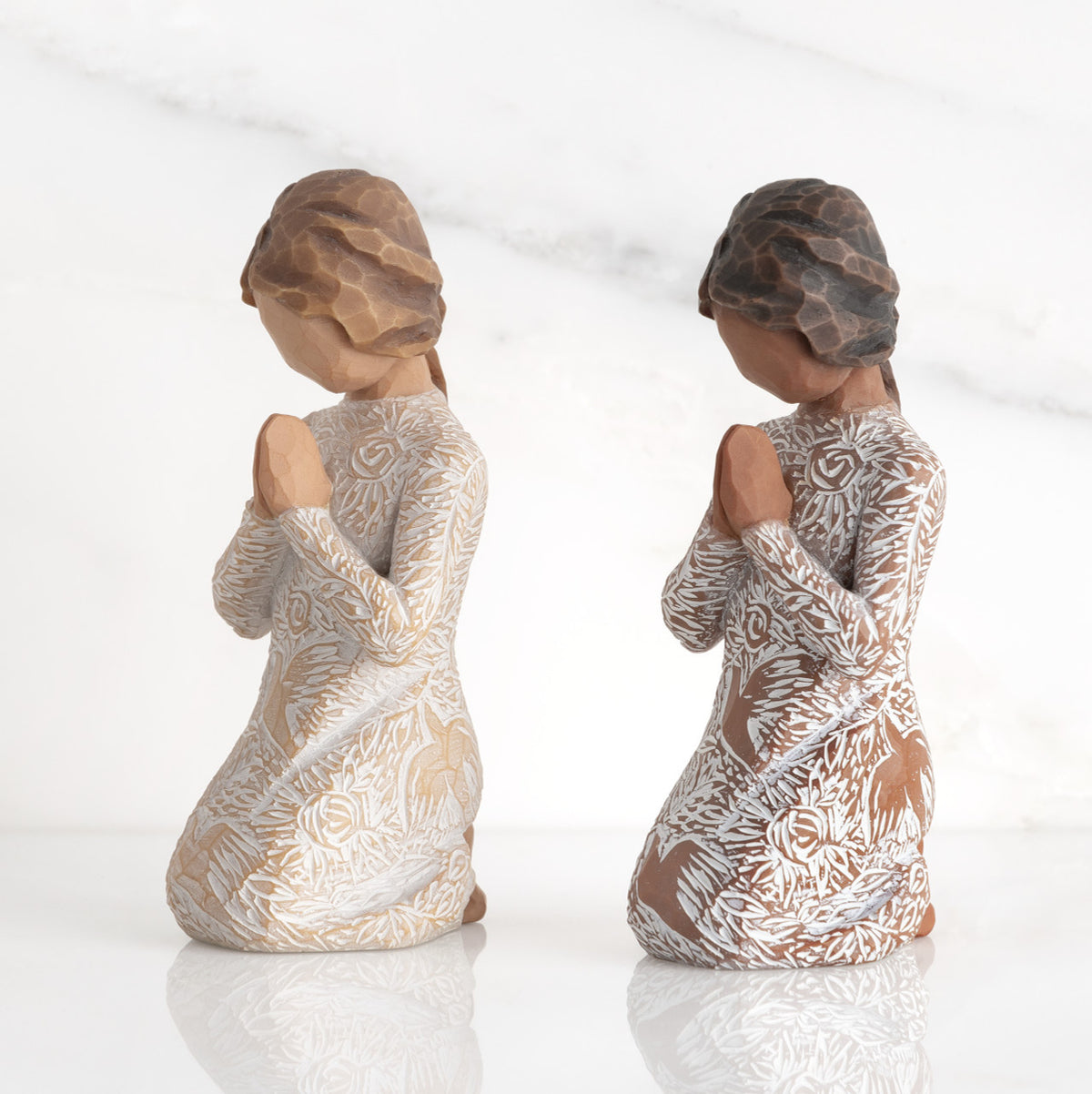 Lighter &amp; Darker skin Kneeling figures, hands in position of prayer or meditation in cream dress carved with icons of nature, lighter and darker skin versions