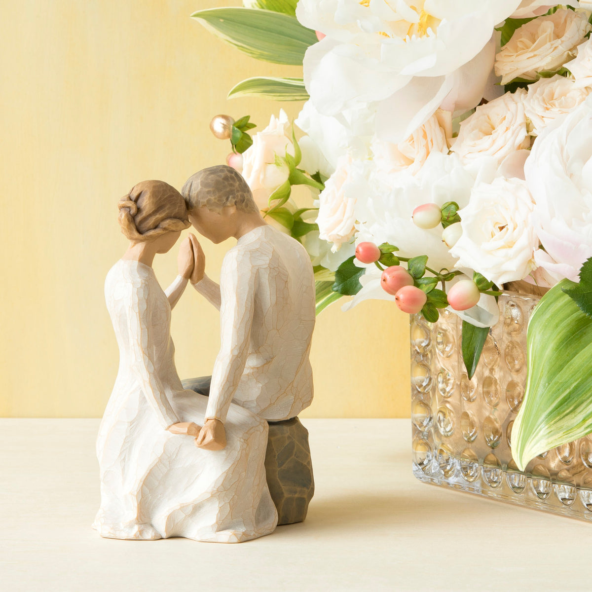 Willow Tree Around You, 6.5”h hand-painted figure of couple seated across from each other, heads and hands together, both in neutral clothing, on table with white roses