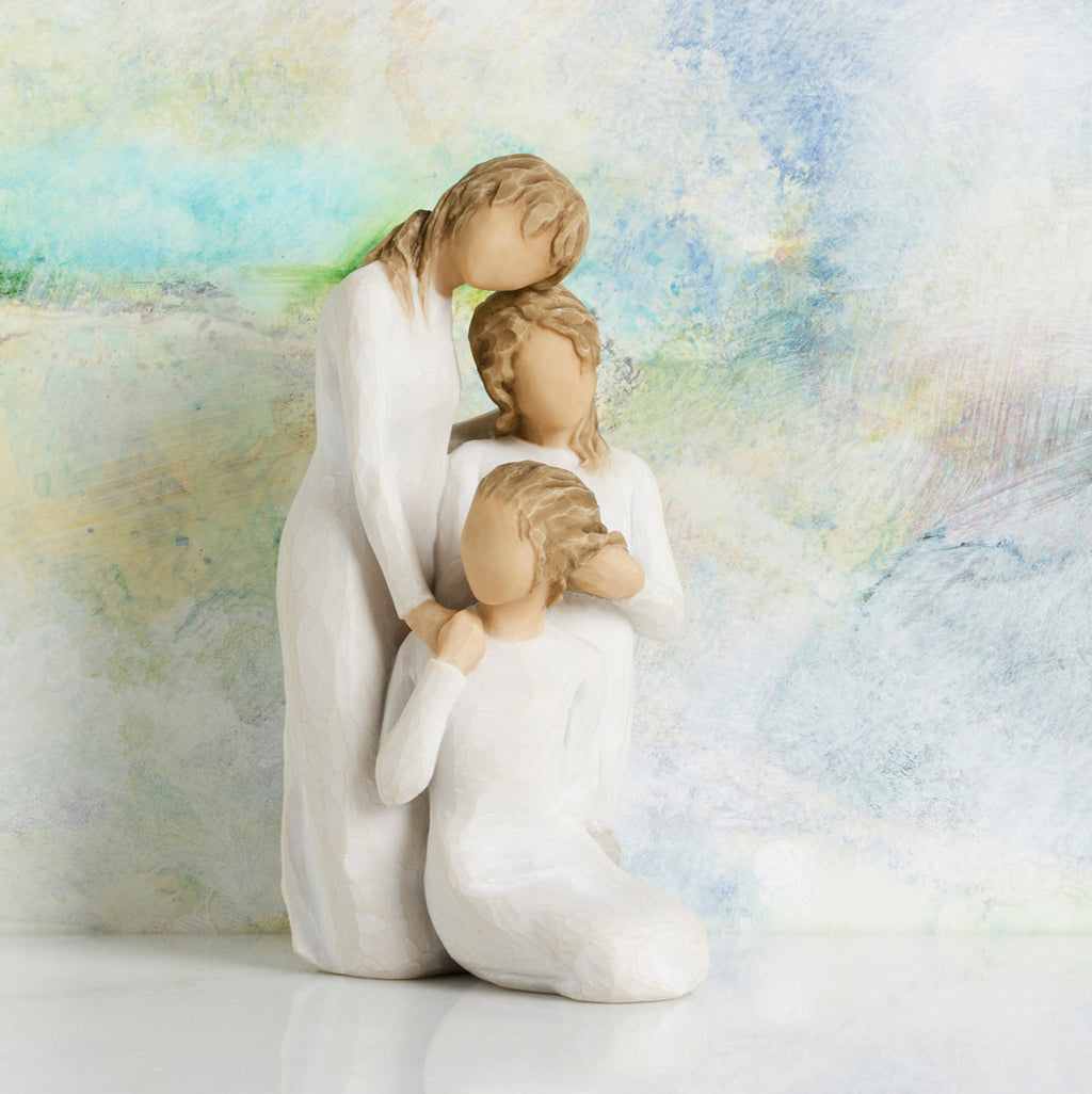 Willow Tree Our healing touch, 6.5”h hand-painted resin figure of three women; one standing with arm around kneeling girl, holding hand of seated girl, kneeling girl arranging hair of seated girl, all in cream dresses, in front of pastel painting